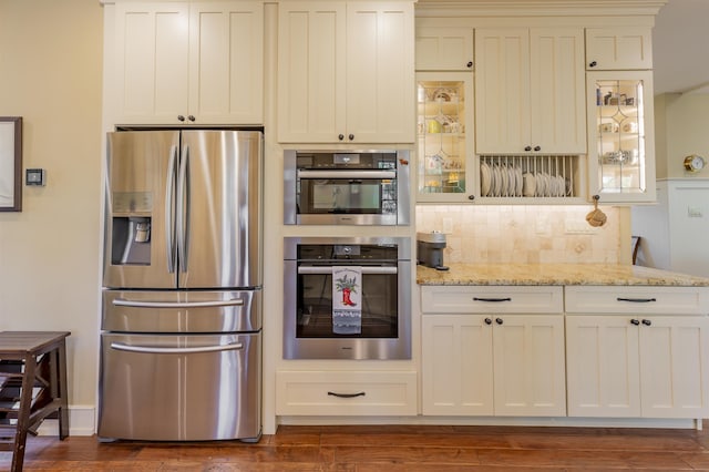 310 Brainard Ave, Cape May Point, NJ 08212 - kitchen with stainless steel appliances, tasteful backsplash, light stone countertops, glass insert cabinets, and dark wood-style flooring