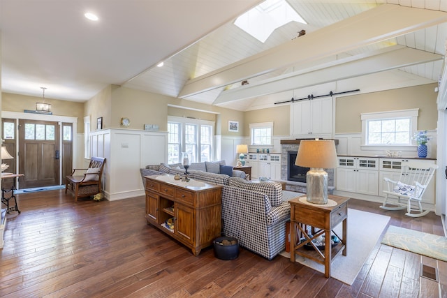 310 Brainard Ave, Cape May Point, NJ 08212 - living area with dark wood-style floors, a skylight, plenty of natural light, a barn door, and wainscoting