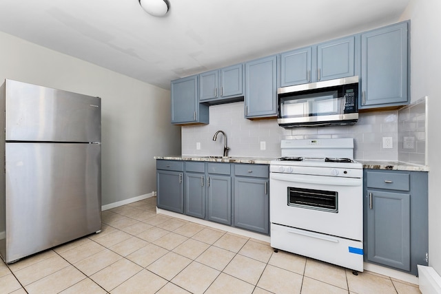 kitchen featuring blue cabinetry, sink, stainless steel appliances, and tasteful backsplash