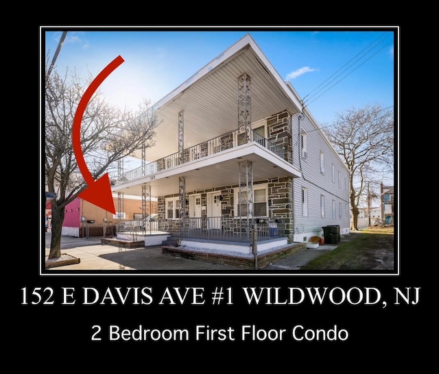 rear view of property featuring a porch and a balcony