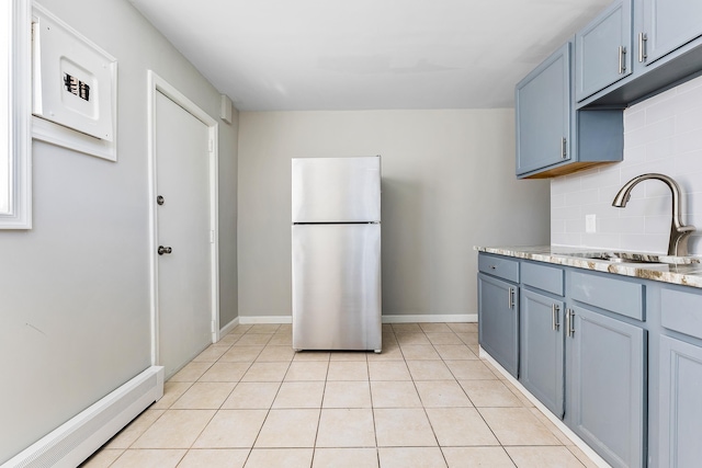 kitchen with stainless steel refrigerator, decorative backsplash, sink, and light tile patterned floors