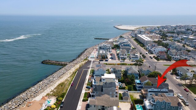 birds eye view of property with a water view and a view of the beach