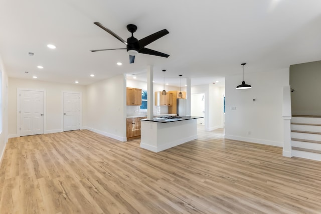 kitchen with ceiling fan, light hardwood / wood-style flooring, a center island, and hanging light fixtures