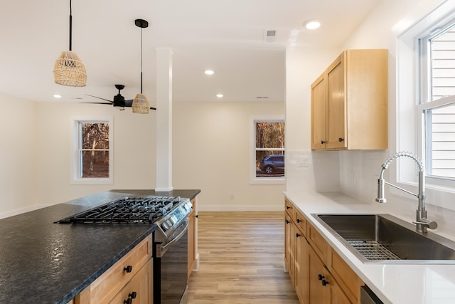 kitchen with light brown cabinetry, ceiling fan, sink, pendant lighting, and black gas stove