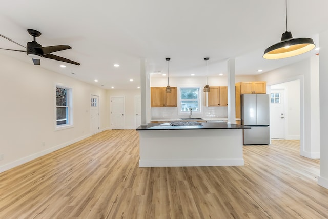 kitchen with sink, light hardwood / wood-style flooring, decorative light fixtures, and appliances with stainless steel finishes