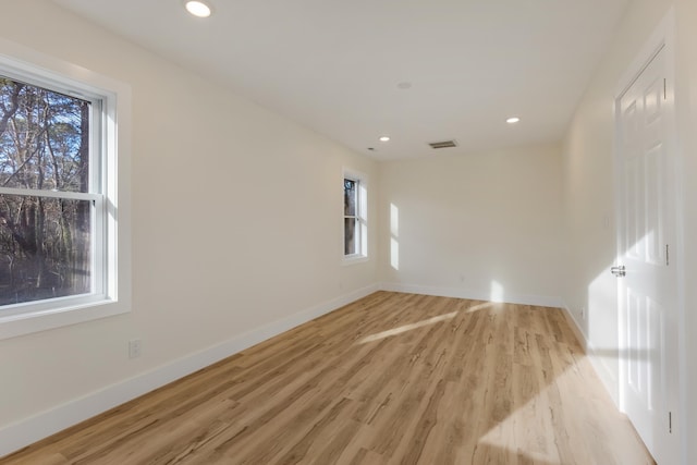 spare room featuring a wealth of natural light and light hardwood / wood-style flooring