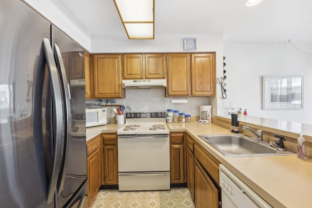 111 Austin Ave Unit 111, Lower Township, NJ 08260 - kitchen with white appliances, under cabinet range hood, a sink, brown cabinets, and light countertops