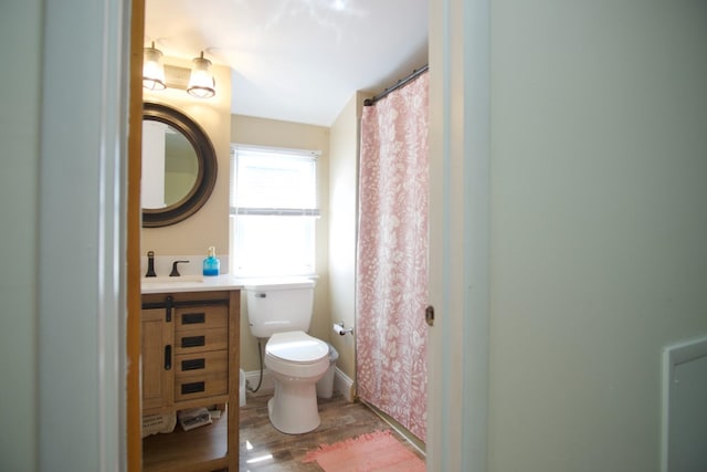 bathroom with hardwood / wood-style flooring, vanity, and toilet