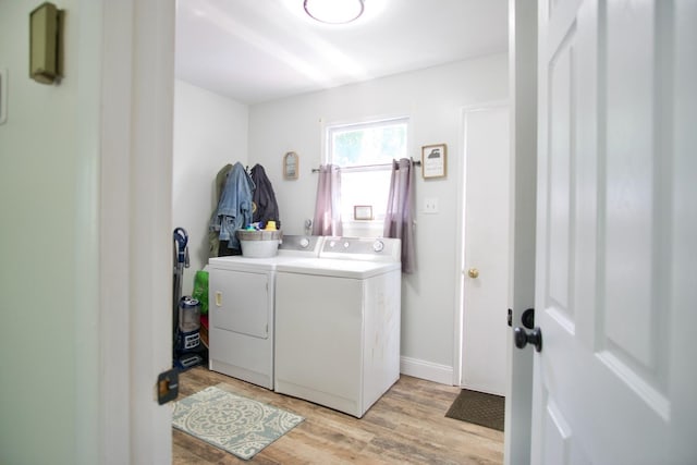 laundry room with washer and clothes dryer and light wood-type flooring