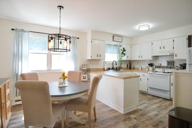 kitchen featuring white range with electric cooktop, white cabinetry, sink, and pendant lighting