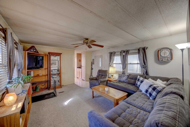 living area with carpet floors, a textured ceiling, and ceiling fan