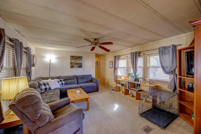 carpeted living room with a textured ceiling and a ceiling fan