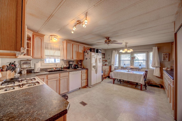 kitchen featuring a sink, white appliances, dark countertops, and light brown cabinets