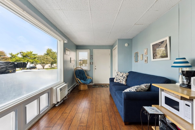 living room featuring a wall mounted air conditioner and dark hardwood / wood-style floors