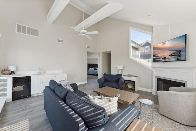 living room with wine cooler, sink, and light hardwood / wood-style floors