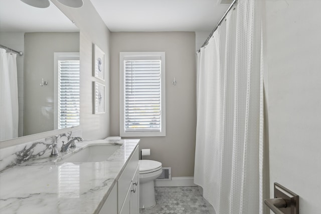 bathroom with tile patterned flooring, vanity, and toilet