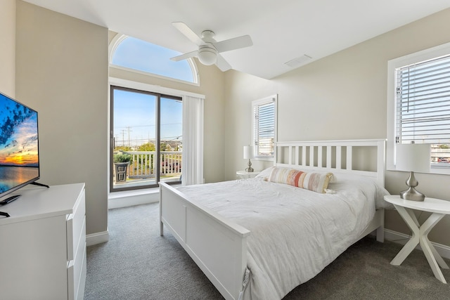 bedroom featuring multiple windows, dark carpet, and ceiling fan