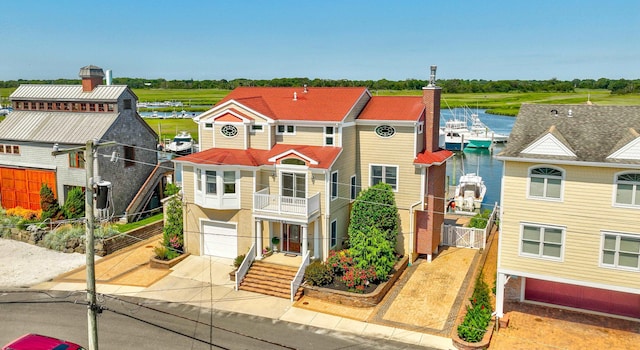 view of front of home with a water view, a garage, and a balcony