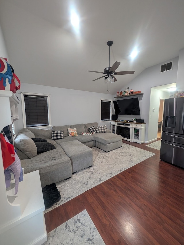 living area featuring lofted ceiling, wood finished floors, visible vents, and ceiling fan