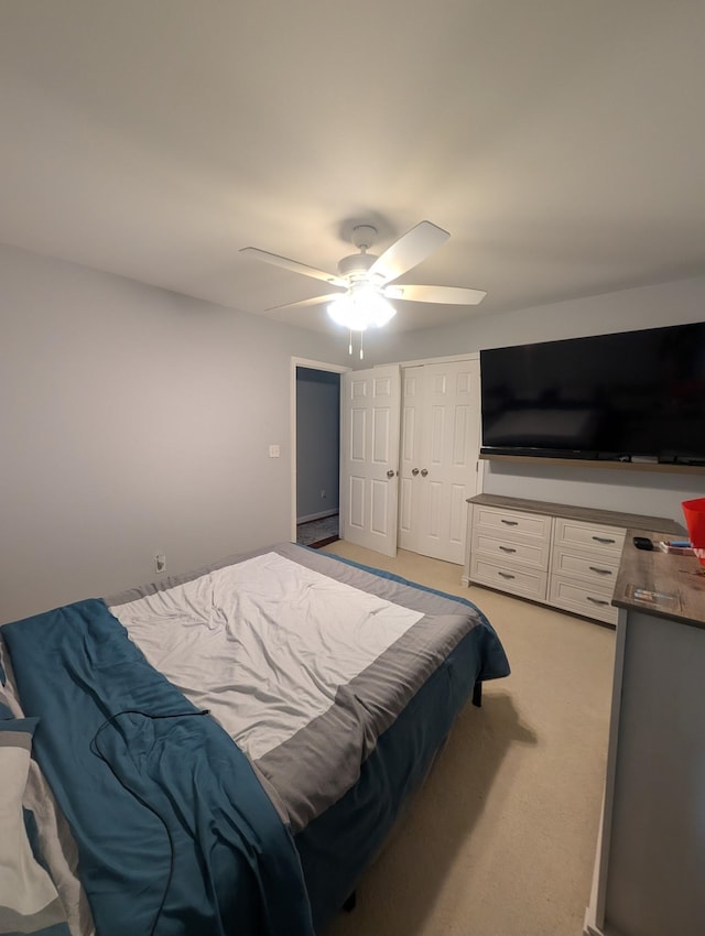 bedroom with a ceiling fan and light colored carpet