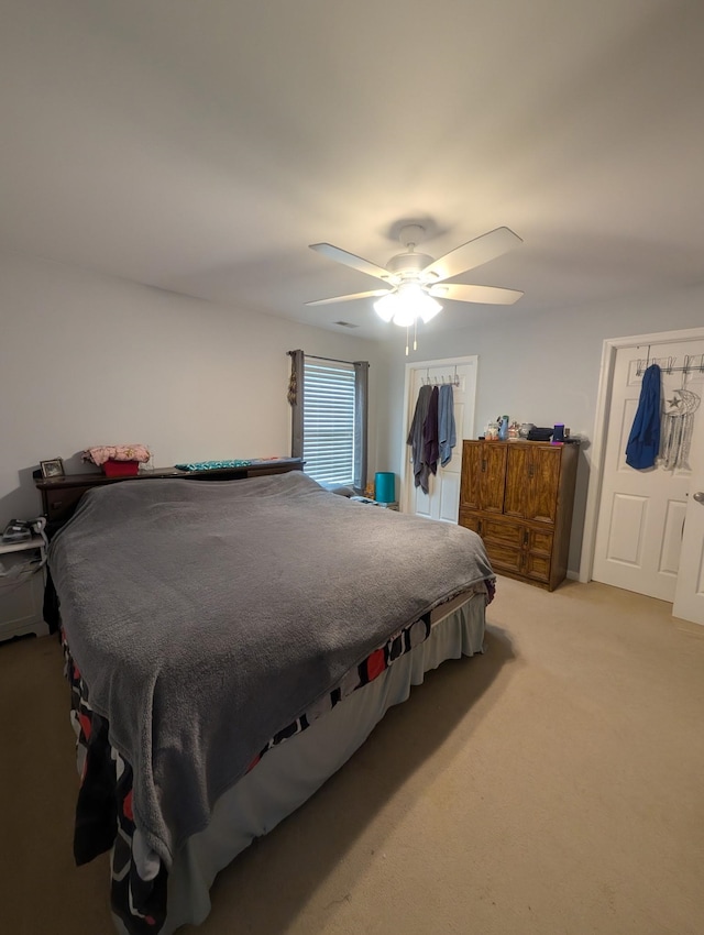 carpeted bedroom with a ceiling fan and a closet