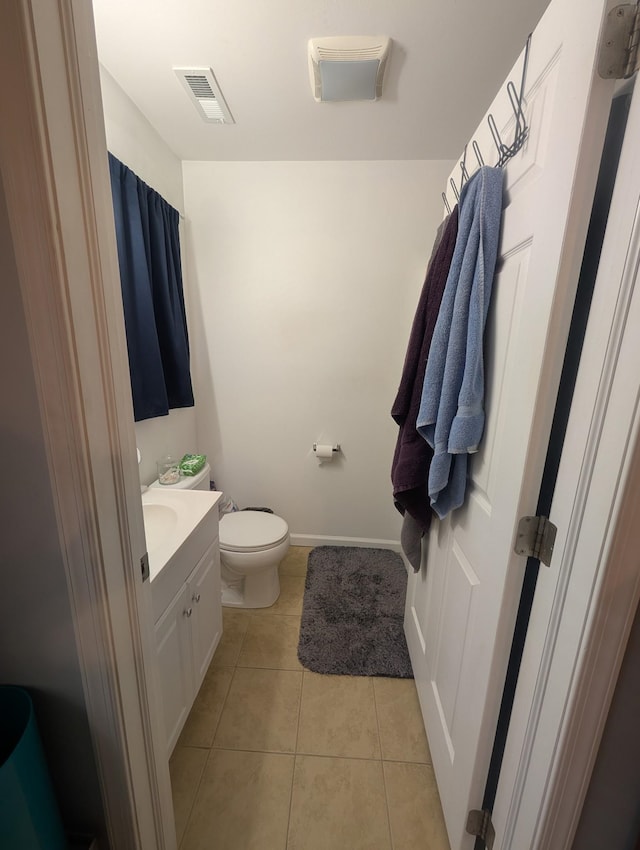 bathroom with tile patterned floors, toilet, baseboards, visible vents, and vanity