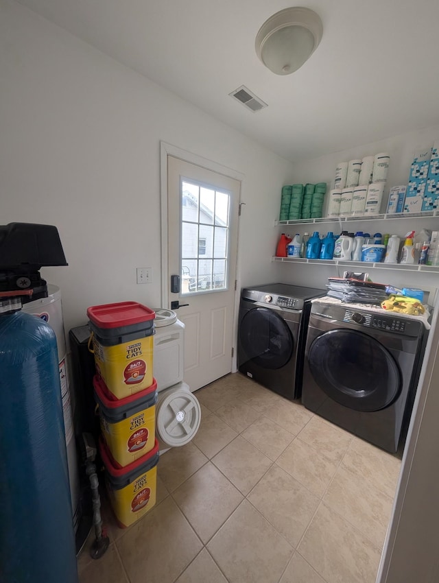 washroom with washer and dryer, laundry area, visible vents, and light tile patterned floors