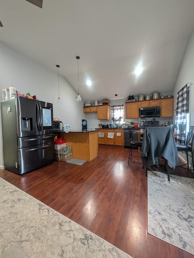 kitchen featuring a peninsula, vaulted ceiling, stainless steel appliances, and dark wood-style floors