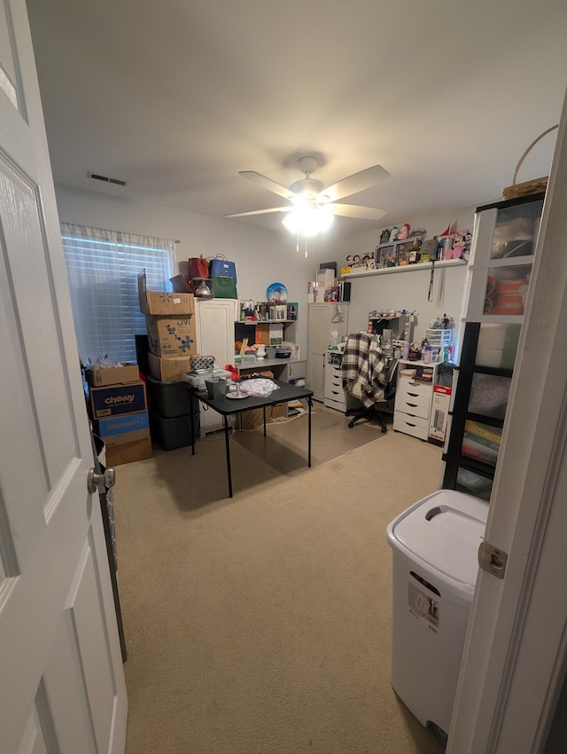 office area with a ceiling fan, carpet flooring, and visible vents