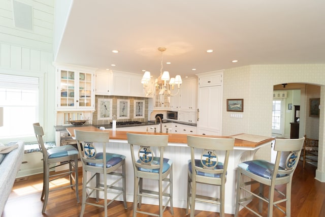 74 W 7th St, Avalon, NJ 08202 - kitchen featuring a chandelier, dark wood-style flooring, glass insert cabinets, wallpapered walls, and white cabinets