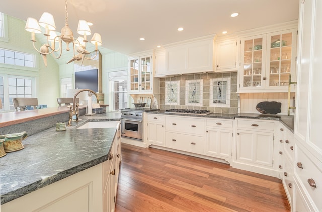 74 W 7th St, Avalon, NJ 08202 - kitchen with a chandelier, light wood-style floors, backsplash, glass insert cabinets, and white cabinets