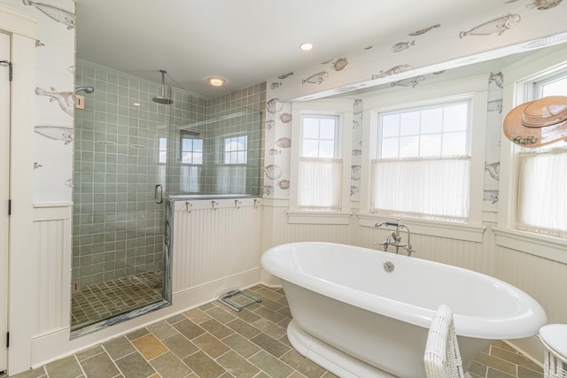 74 W 7th St, Avalon, NJ 08202 - bathroom featuring a stall shower, plenty of natural light, a freestanding tub, wainscoting, and a decorative wall