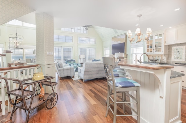 74 W 7th St, Avalon, NJ 08202 - kitchen featuring a chandelier, wood finished floors, glass insert cabinets, white cabinetry, and open floor plan