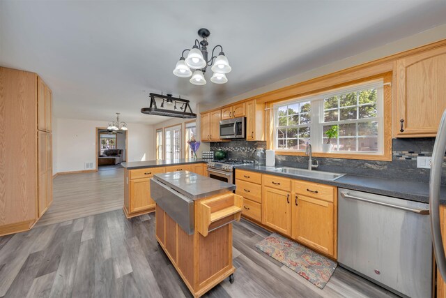 15 4th Ave, Cape May Court House, NJ 08210 - kitchen with appliances with stainless steel finishes, a chandelier, a peninsula, decorative backsplash, and dark countertops