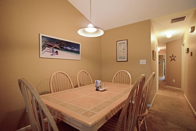 dining room with light carpet and lofted ceiling