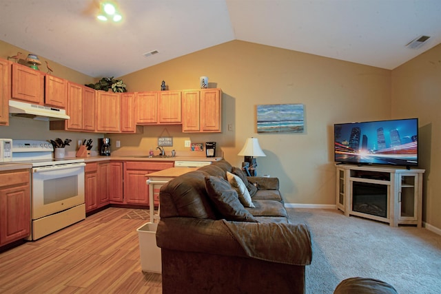 kitchen with sink, light hardwood / wood-style flooring, white range with electric cooktop, vaulted ceiling, and light brown cabinetry