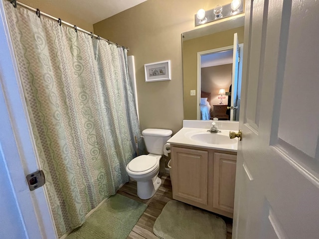 bathroom with hardwood / wood-style floors, vanity, and toilet