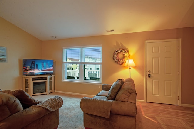 carpeted living room featuring vaulted ceiling