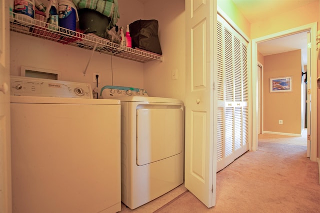 laundry room with washing machine and dryer and light colored carpet