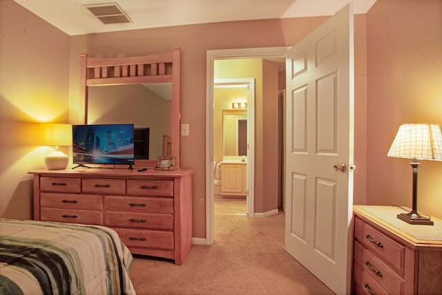 bedroom with light carpet and ensuite bath