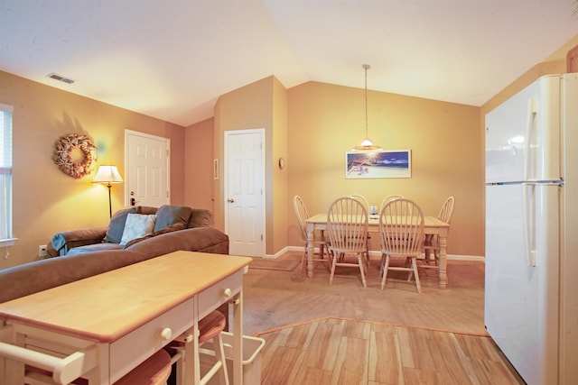 dining room with light hardwood / wood-style floors and lofted ceiling