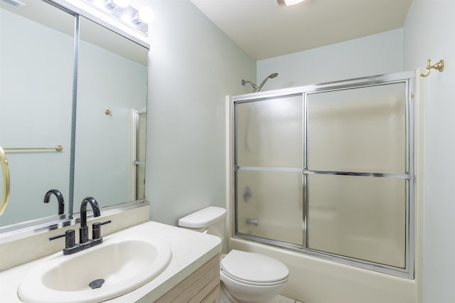 bathroom featuring visible vents, combined bath / shower with glass door, vanity, and toilet
