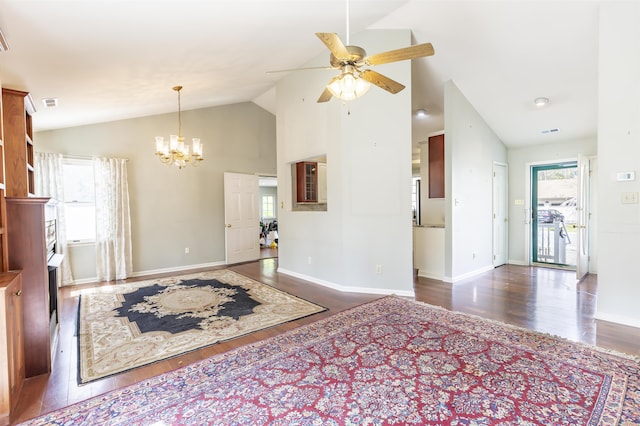 interior space with vaulted ceiling, baseboards, wood finished floors, and ceiling fan with notable chandelier