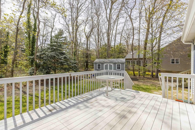 deck with an outdoor structure, a yard, and a shed