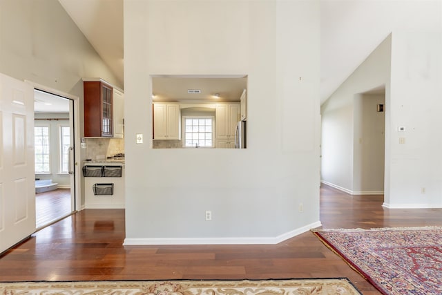 interior space with freestanding refrigerator, plenty of natural light, and dark wood-style flooring