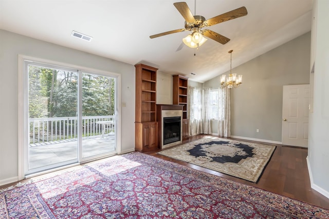 living room featuring wood finished floors, visible vents, baseboards, and ceiling fan with notable chandelier