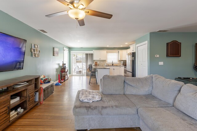 living room with light wood-style floors, recessed lighting, ceiling fan, and visible vents