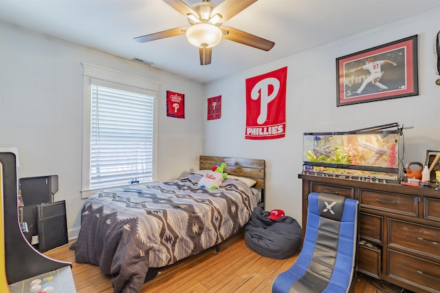 bedroom featuring visible vents, a ceiling fan, and hardwood / wood-style floors