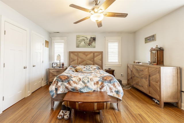 bedroom featuring a ceiling fan, baseboards, and light wood-style flooring