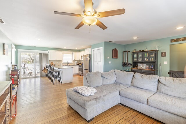 living area featuring recessed lighting, a ceiling fan, light wood finished floors, and visible vents
